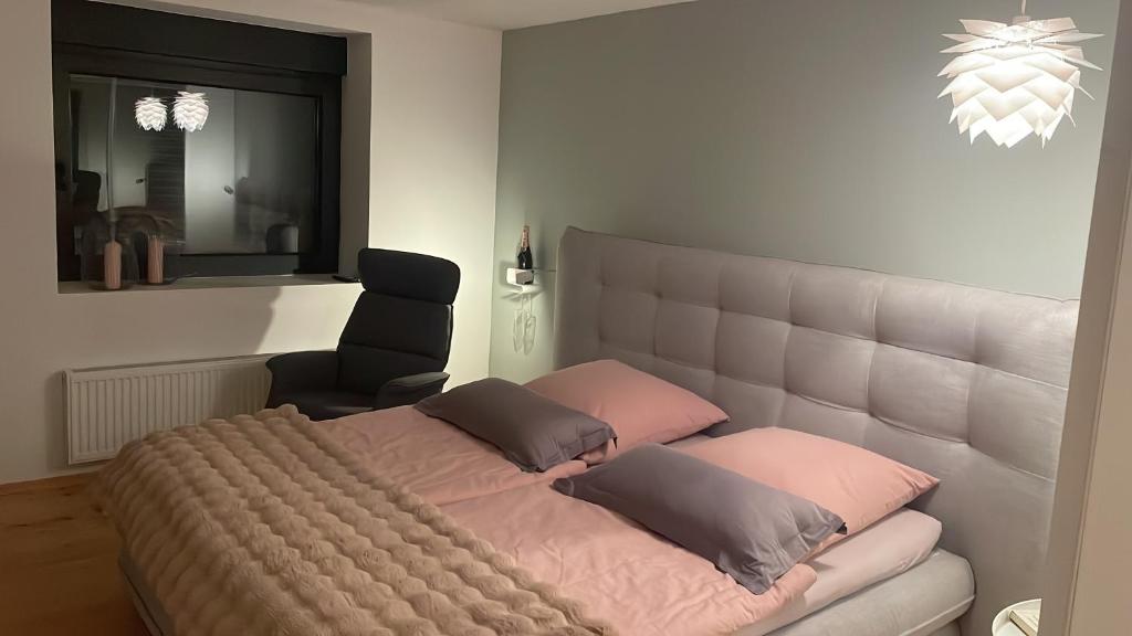 a bed with two pillows and a chair in a room at WOOD hOUSE in Vrbovsko