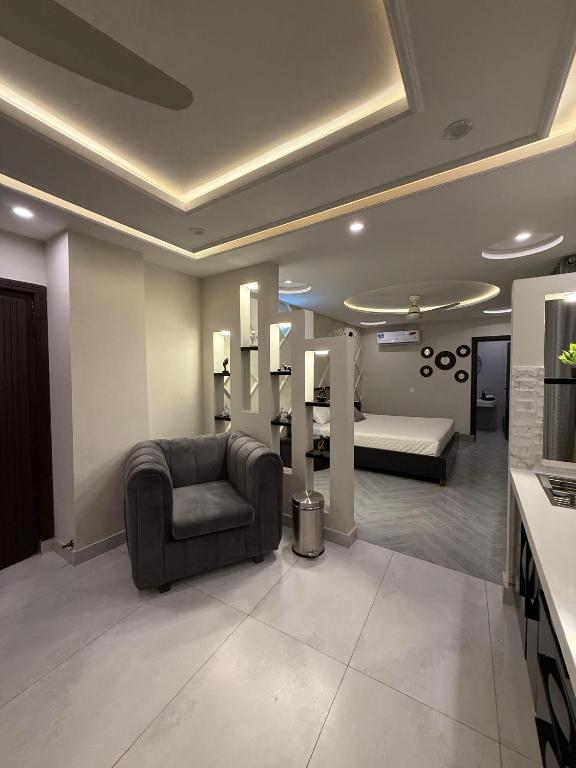 a living room with a chair and a bed at Serenity Residence Room Studio 1BHK in Rachiāl