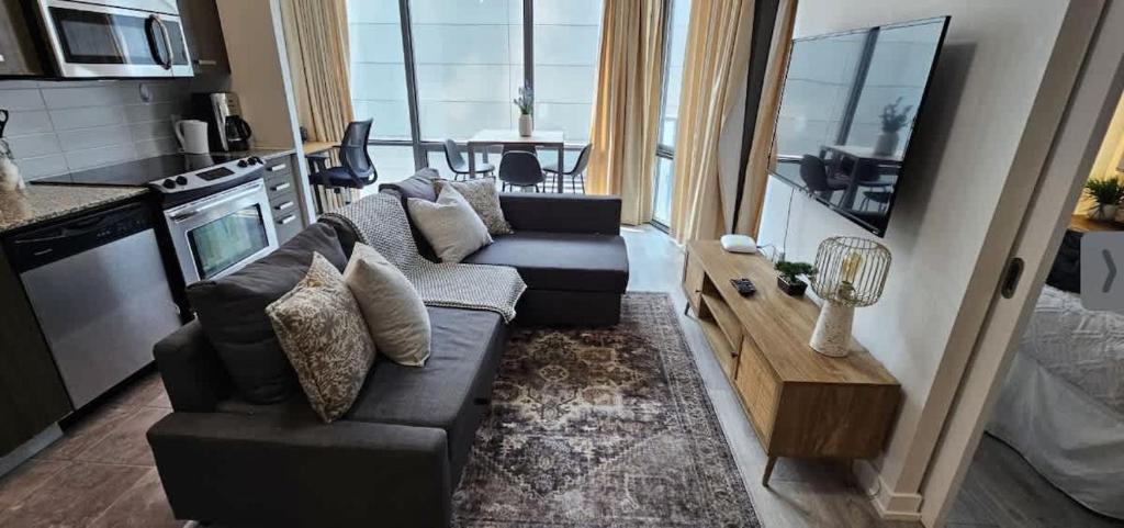 a living room with a couch and a table in a kitchen at Functional Condo Sleep 6 in Port Hope