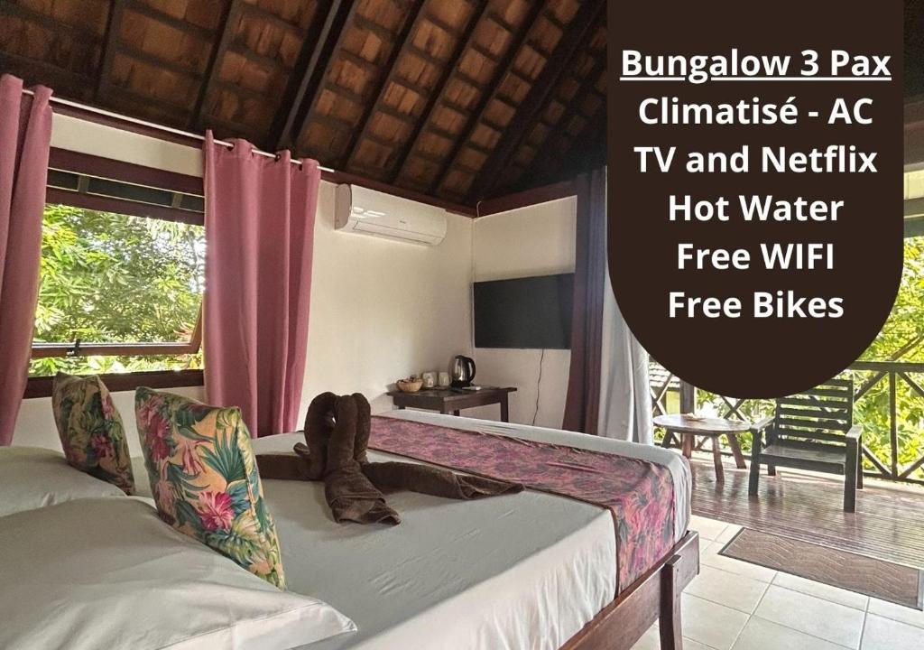 a bedroom with a bed and a window at Pension Hibiscus Taha'a in Vaitoare