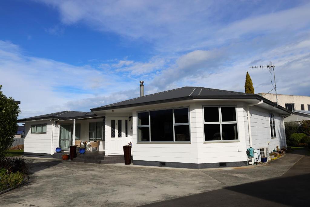 a white house with a black roof at Rev it up Homestay in Feilding