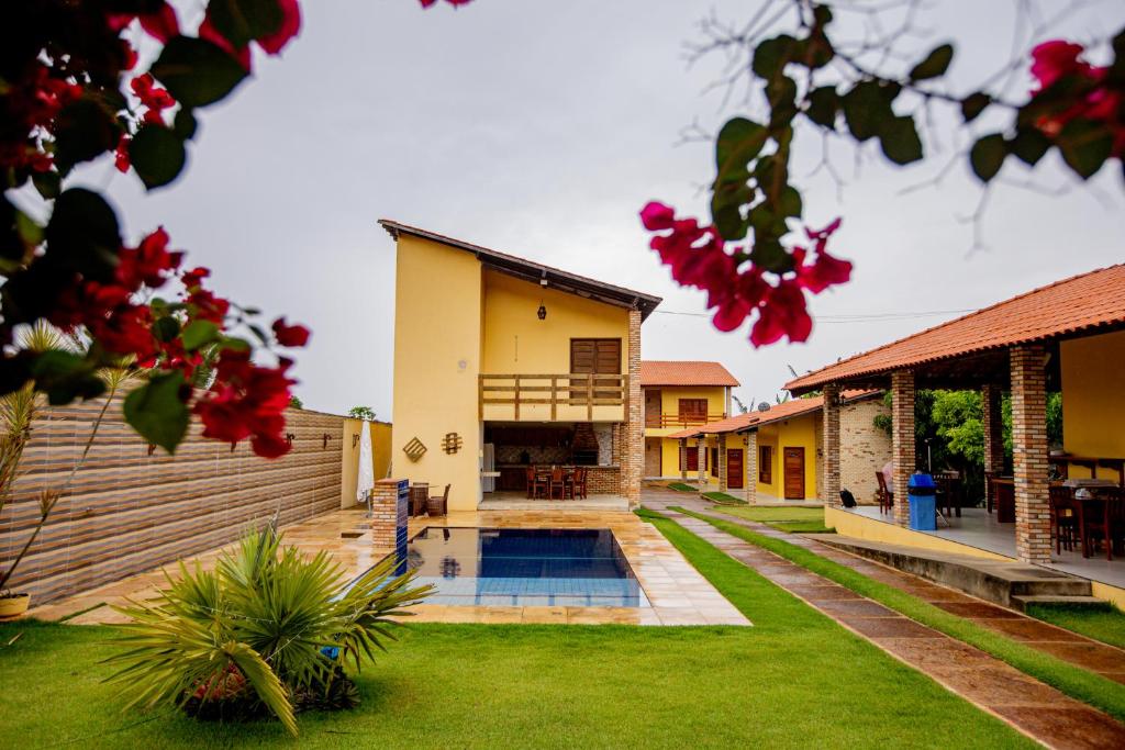 a house with a swimming pool in a yard at Pousada Sítio Machado in Viçosa do Ceará