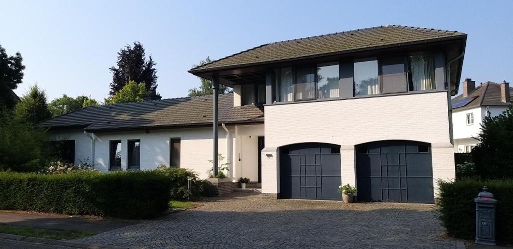 a large white house with two garage doors at logies Huis Liselotte in Genk