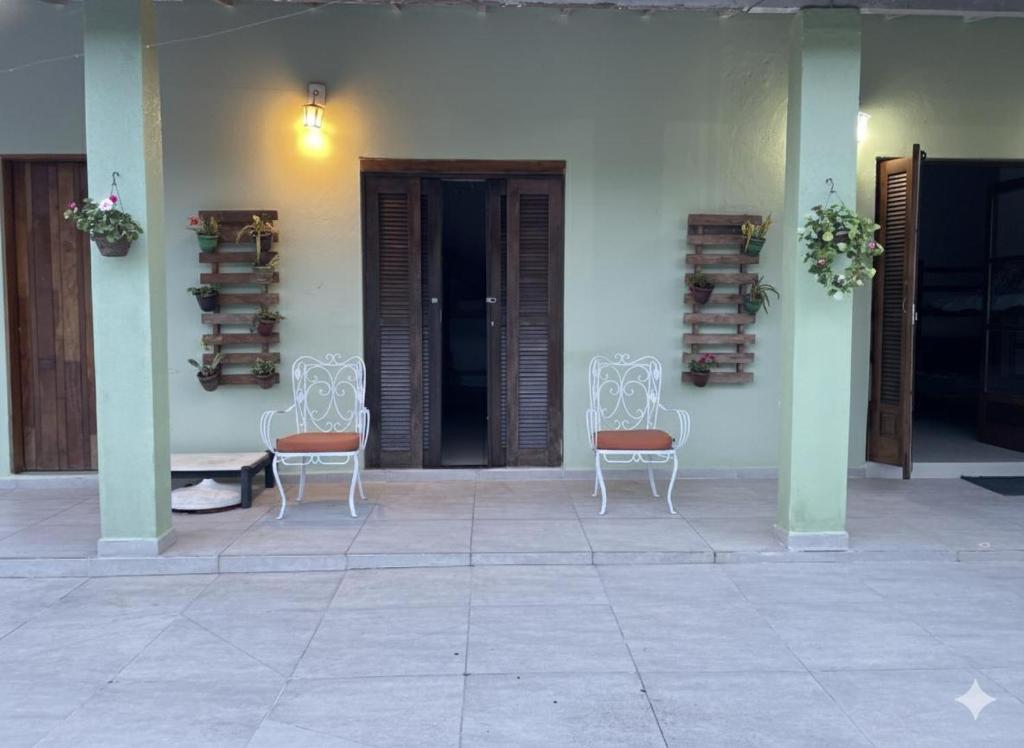 a group of chairs sitting in front of a building at Pousada NASCER DO SOL in Bertioga