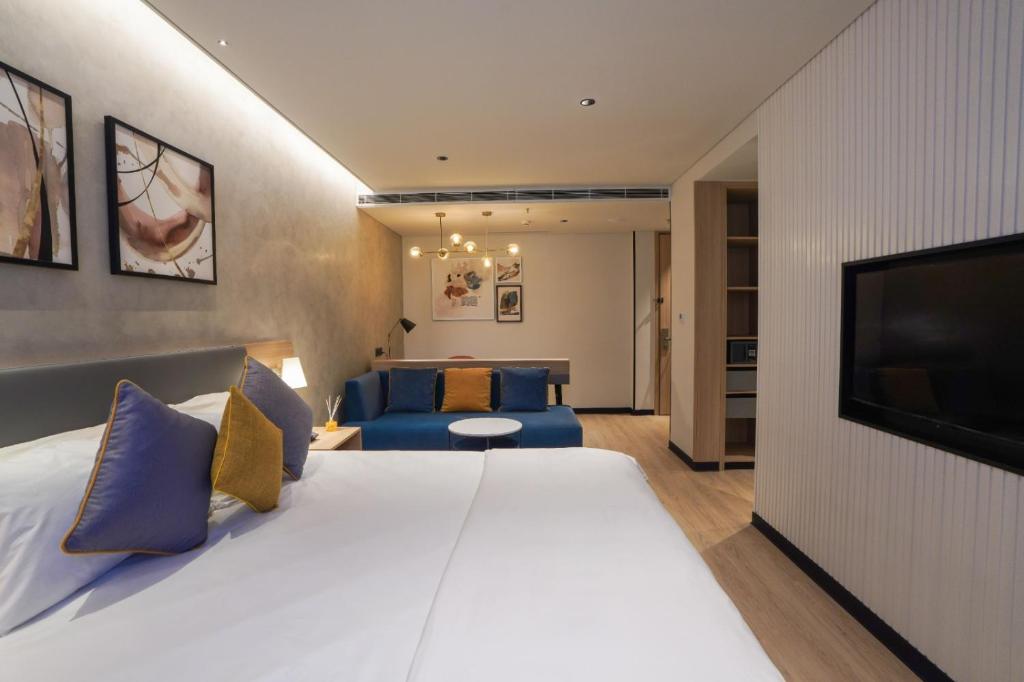 a hotel room with a large bed and a television at The Canvas Loft-Manyata Tech Park-Orchid Parc in Bangalore