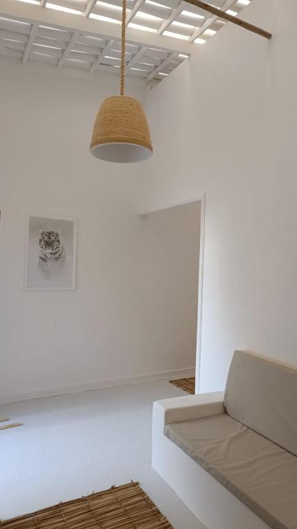 a living room with a couch and a light fixture at Casa Carnaubas in Icapuí