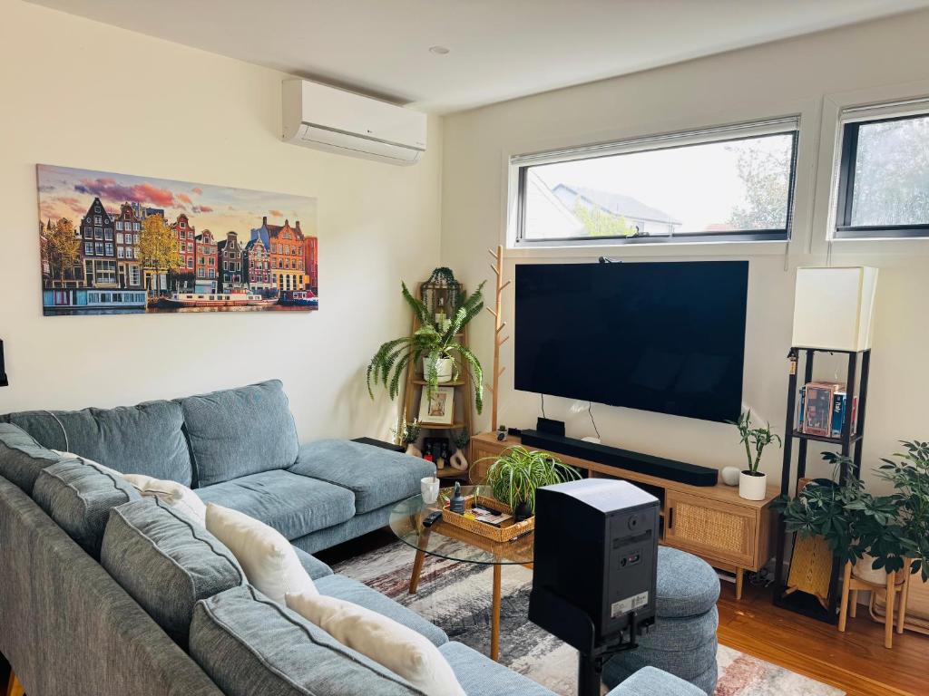 a living room with a couch and a flat screen tv at Quiet and Cozy corner in Braybrook