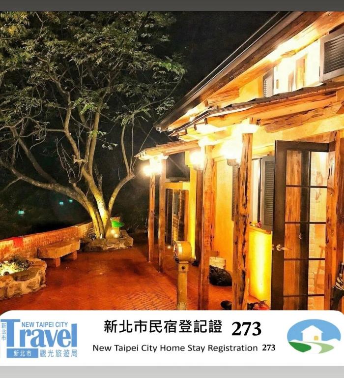 a picture of a house with a tree painted on it at Luck Homestay in Jiufen
