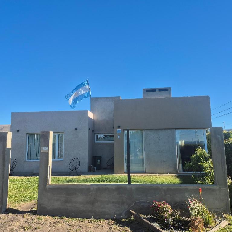 ein Haus mit einer Flagge davor in der Unterkunft OLIEMI in El Calafate