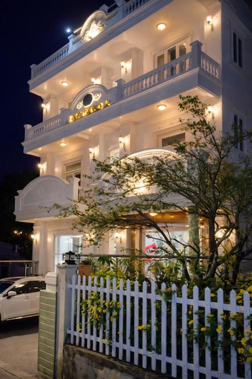a white fence in front of a white building at Bình Dương Đà Lạt Hotel in Da Lat