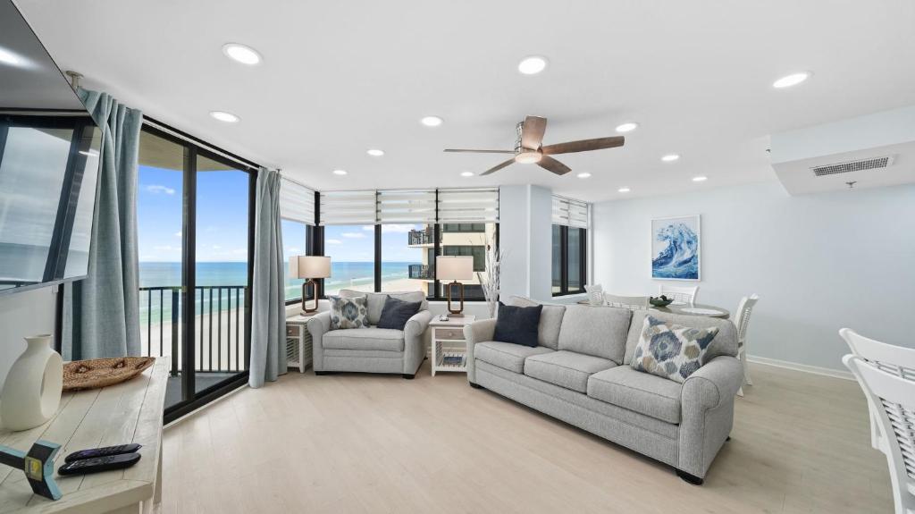 a living room with a couch and a ceiling fan at Steps to the beach and amazing views! in Panama City Beach