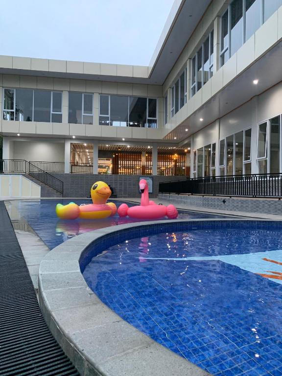 a swimming pool with inflatables in front of a building at Prima SR Hotel & Convention Yogyakarta in Yogyakarta