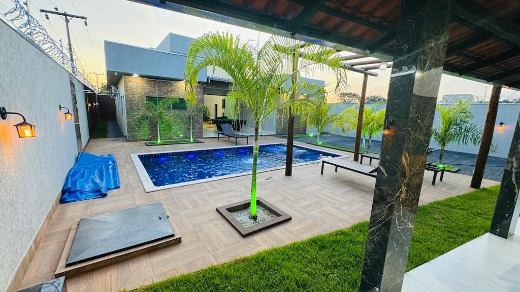 a courtyard with a pool and a palm tree at Rancho Paradise Aruanã GO in Aruanã