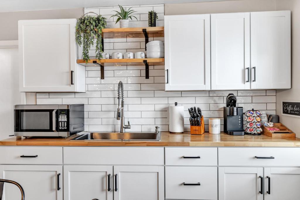 a kitchen with white cabinets and a sink at Newly renovated-across the street from Von Stiehl! in Algoma