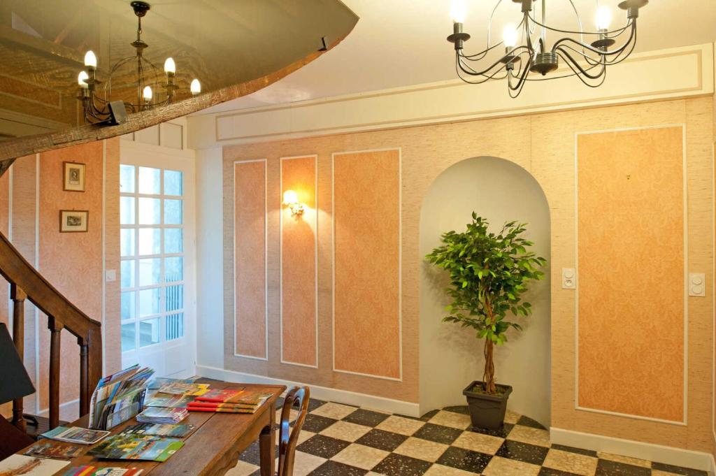 a dining room with a table and a potted plant at Le balcon de la crémaillère in Langres