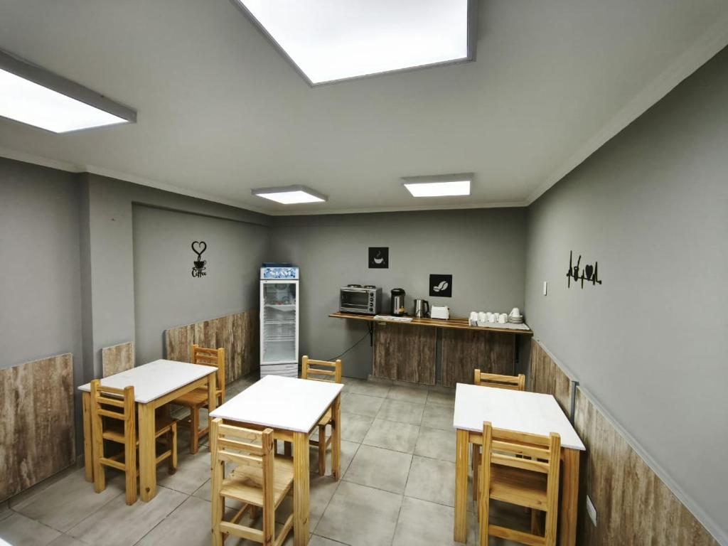a restaurant with tables and chairs and a counter at HOTEL EL VIEJO Bar in Perito Moreno