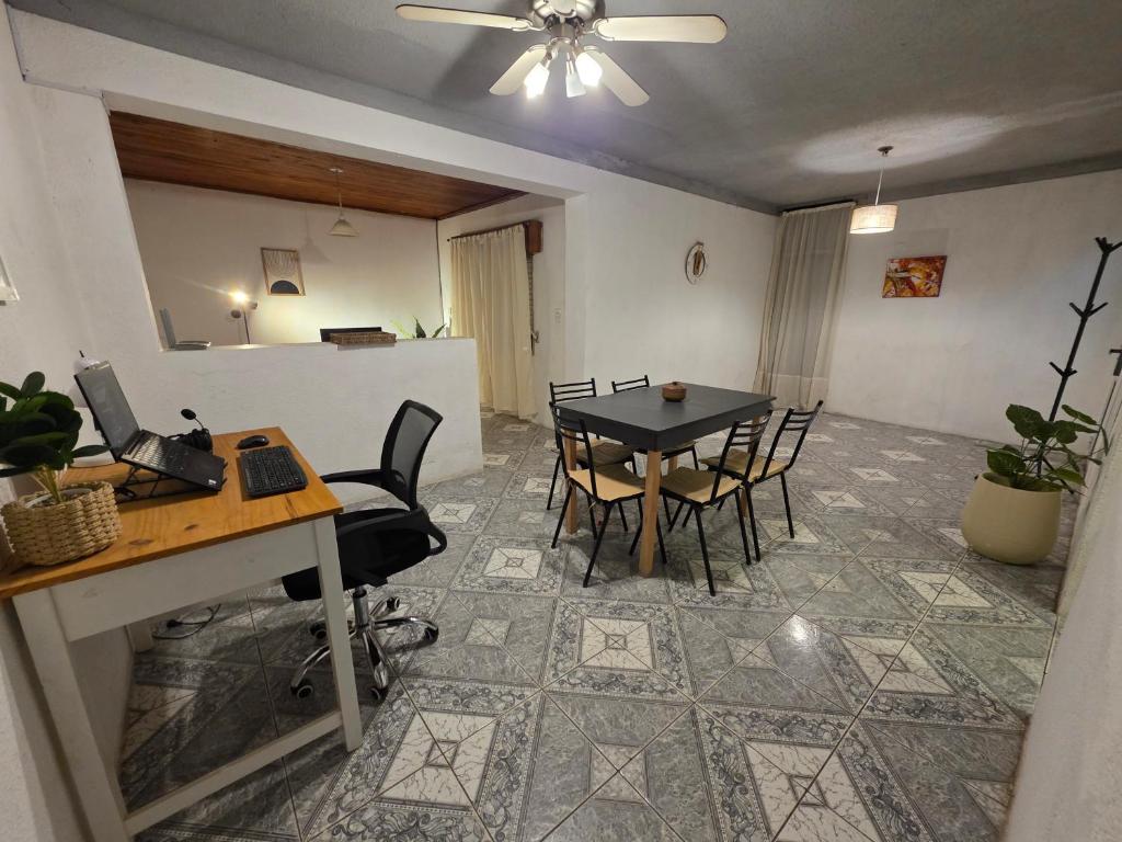 a dining room with a table and chairs and a laptop at Departamento dos dormitorios en 3er piso por escaleras in Chajarí