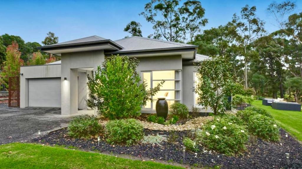 a small white house with a yard at The Grand Oasis in Donvale