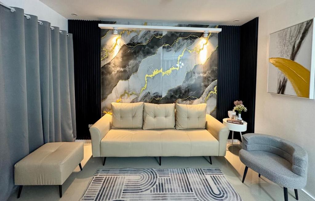 a living room with a white couch and a painting at Skyline Abode Antipolo in Antipolo