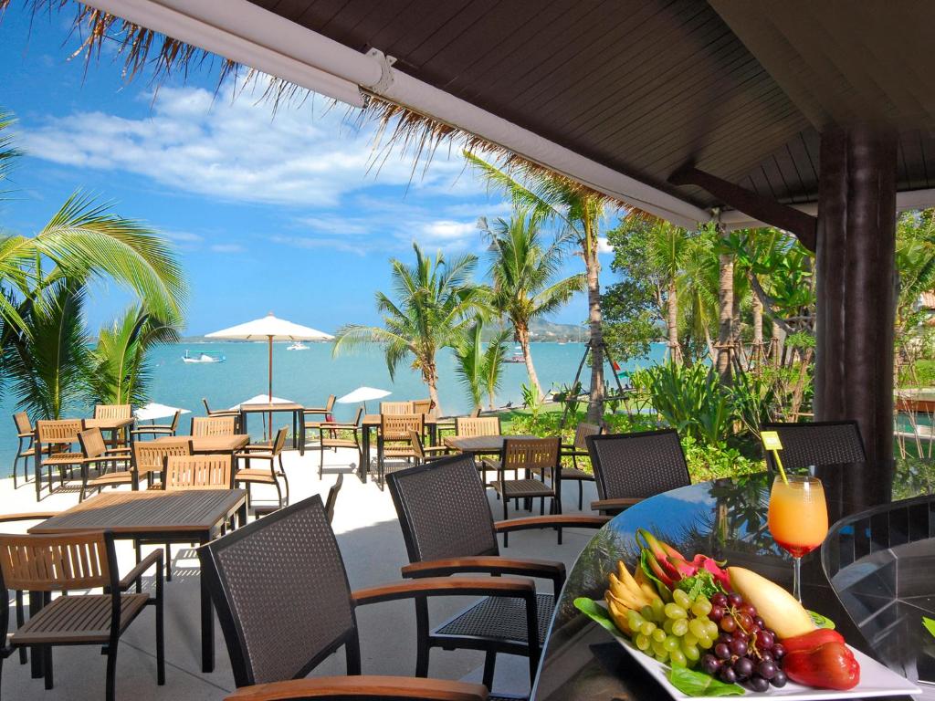 a table with a bowl of fruit on a table at Hotel Ibis Samui Bophut in Bophut