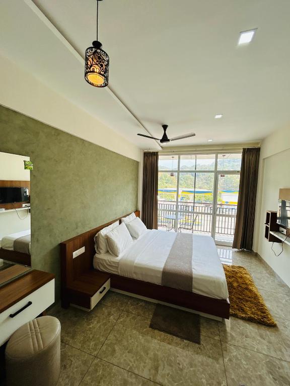a bedroom with a large bed and a balcony at Dreamwagon hotel lakkidi in Vythiri