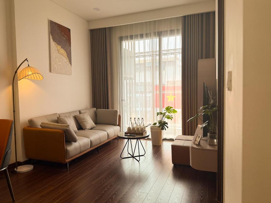 a living room with a couch and a large window at A Quiet Stay - Service Apartment, Vinhome Ocean Park, Ha Noi in Gia Lâm Pho
