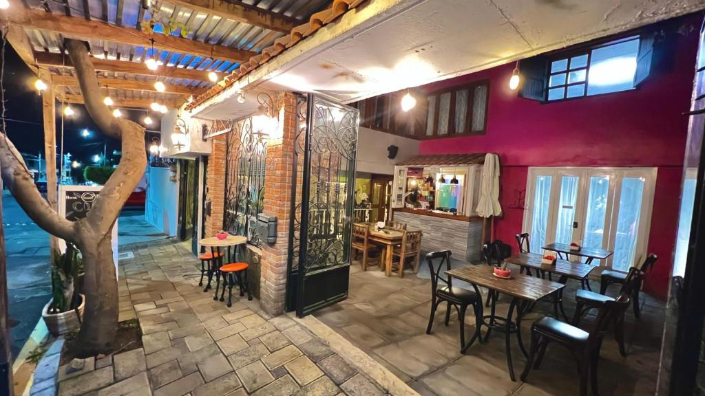 a restaurant with tables and chairs and a red wall at Hostal Mago in Tlaxcala de Xicohténcatl