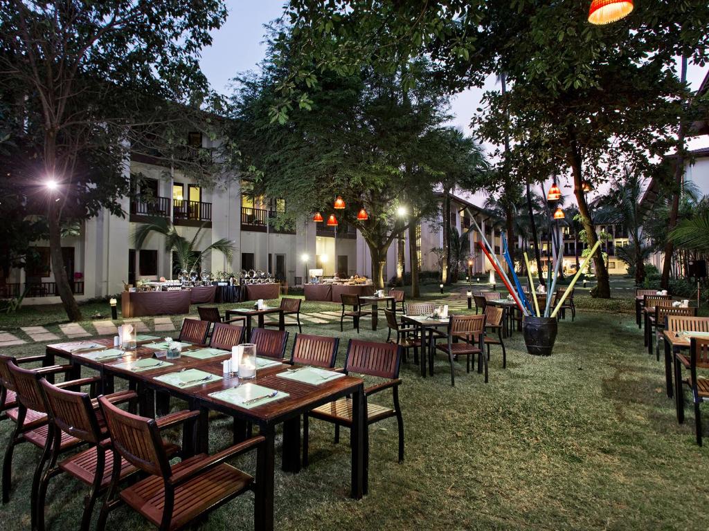 a restaurant with tables and chairs in a park at night at Hotel Ibis Samui Bophut in Bophut