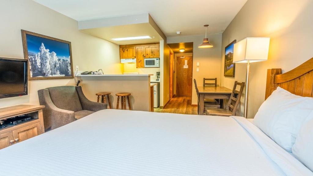a hotel room with a bed and a kitchen at Cahilty #247 in Sun Peaks