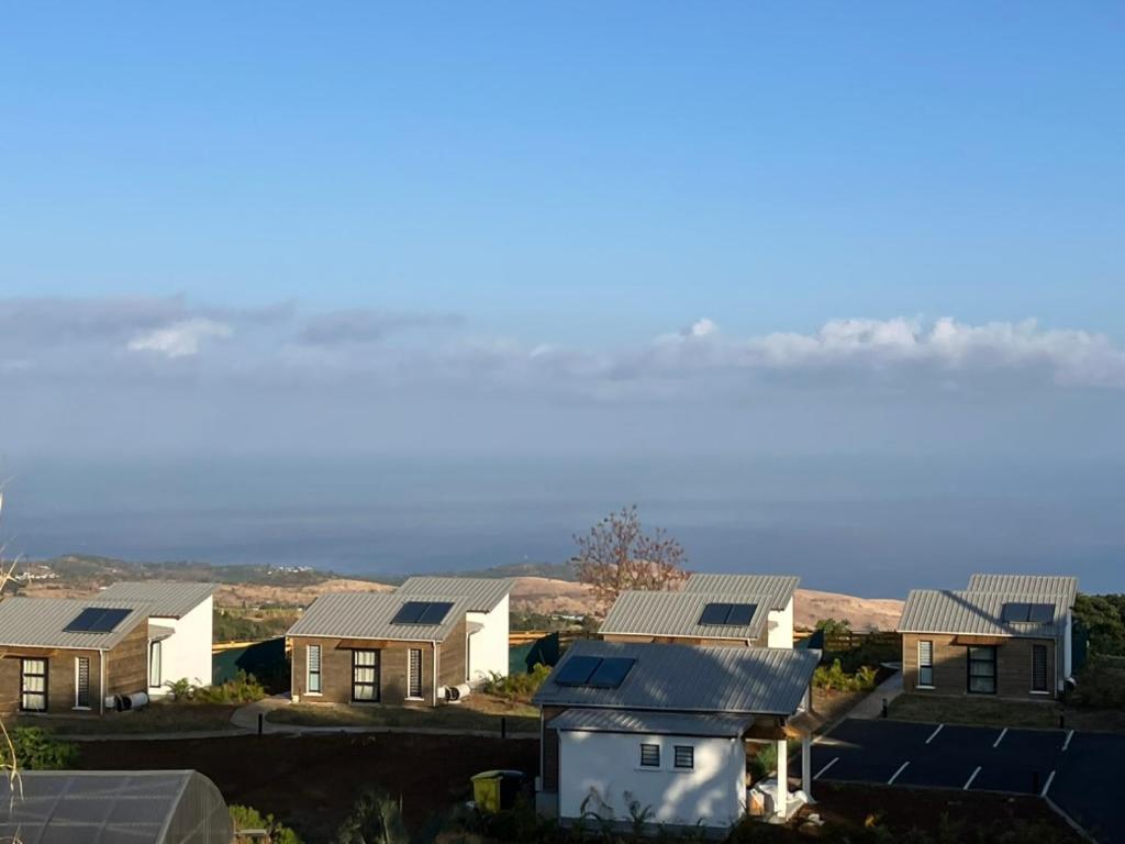 a row of houses with the ocean in the background at Sagar Réunion in Saint-Paul