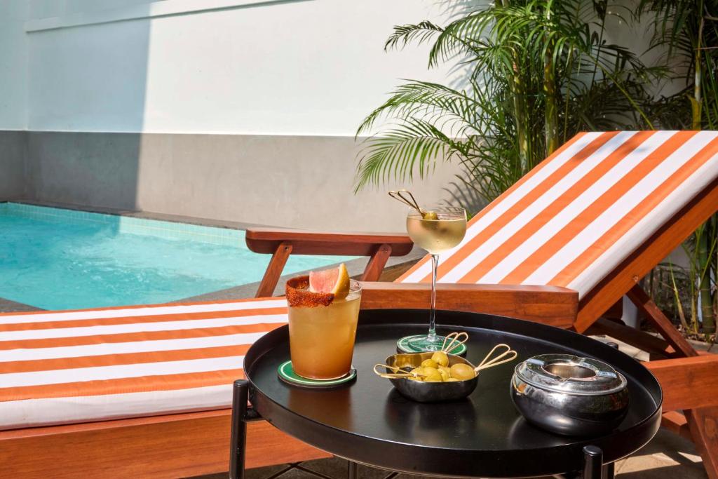a table with a drink on top of a patio at The Passport Hotel in Assagao