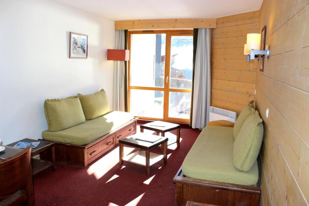 ヴァル・トランスにあるTemples Du Soleil Tikal Appartements VTIのソファと窓が備わるホテルルームです。