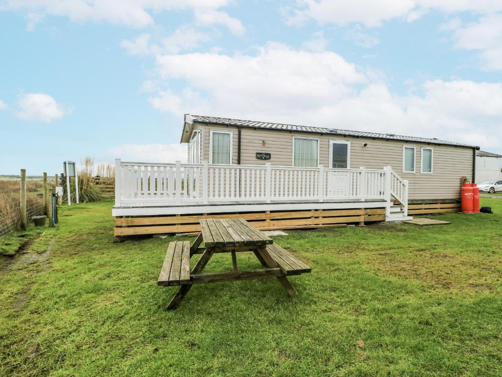 a picnic table in front of a tiny house at Trewan Chalet in Holyhead