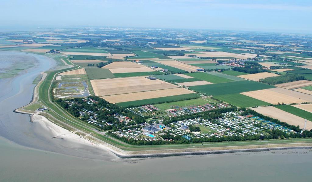 une vue aérienne d'une ferme près de l'eau dans l'établissement Camping Scheldeoord, à Baarland