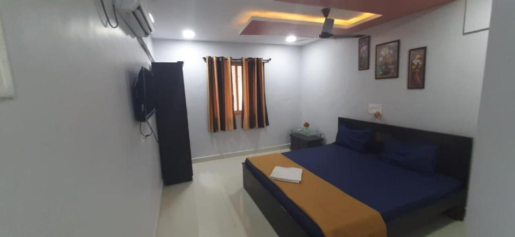 a bedroom with a blue bed in a room at Hotel Radha krishna in Neral