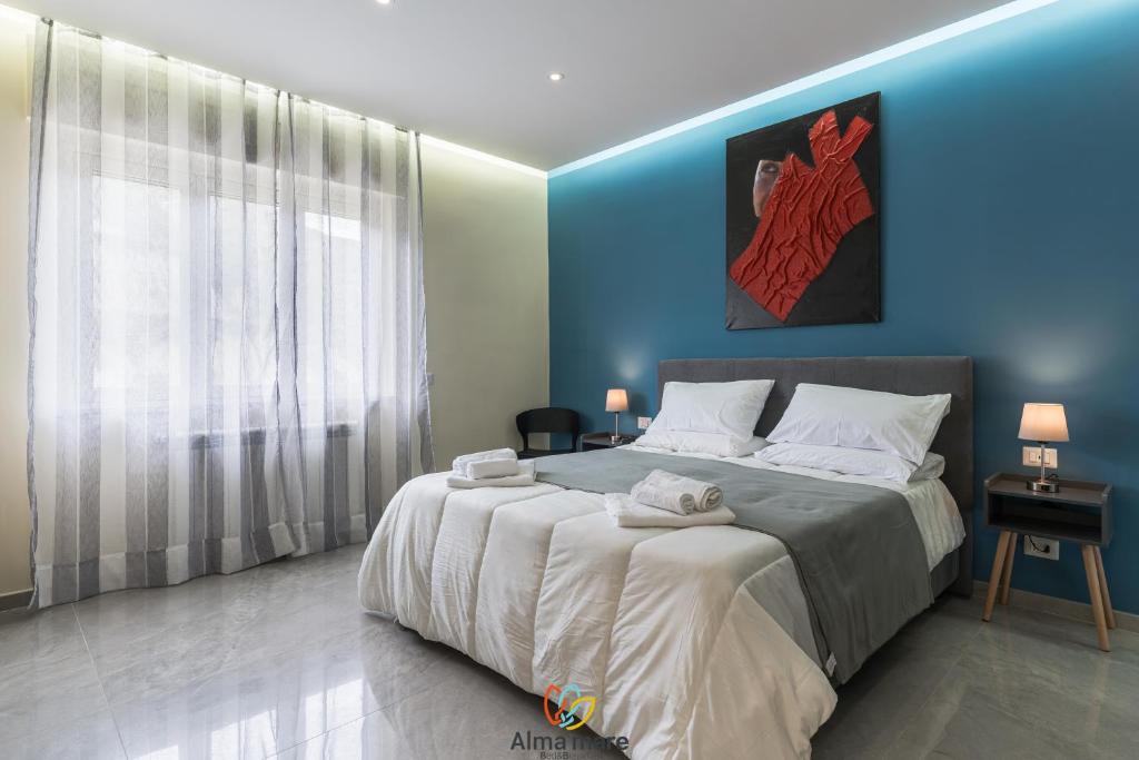 a bedroom with a large bed with a blue wall at Alma Mare in Crotone