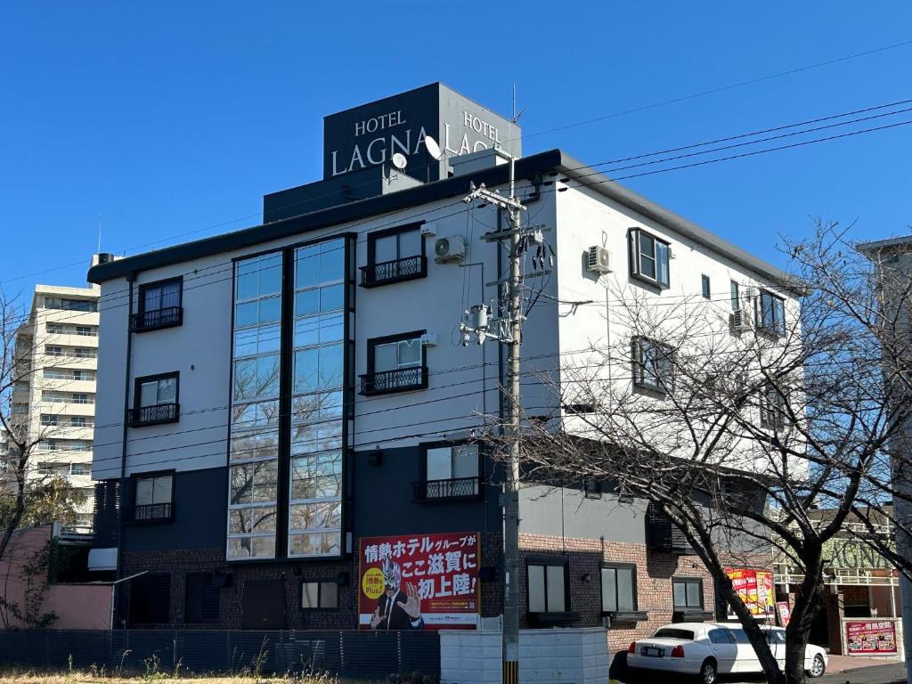 a building with a sign on the side of it at Hotel LAGNA in Moriyama