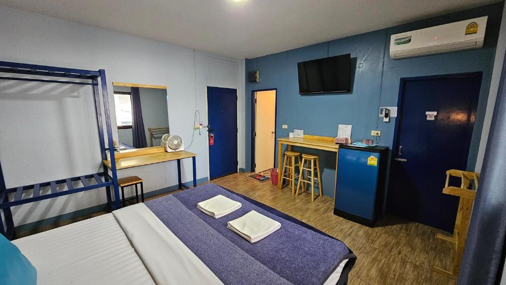 a small room with a bed and a kitchen at Blueplace บลูเพลส in Ban Talat Rangsit