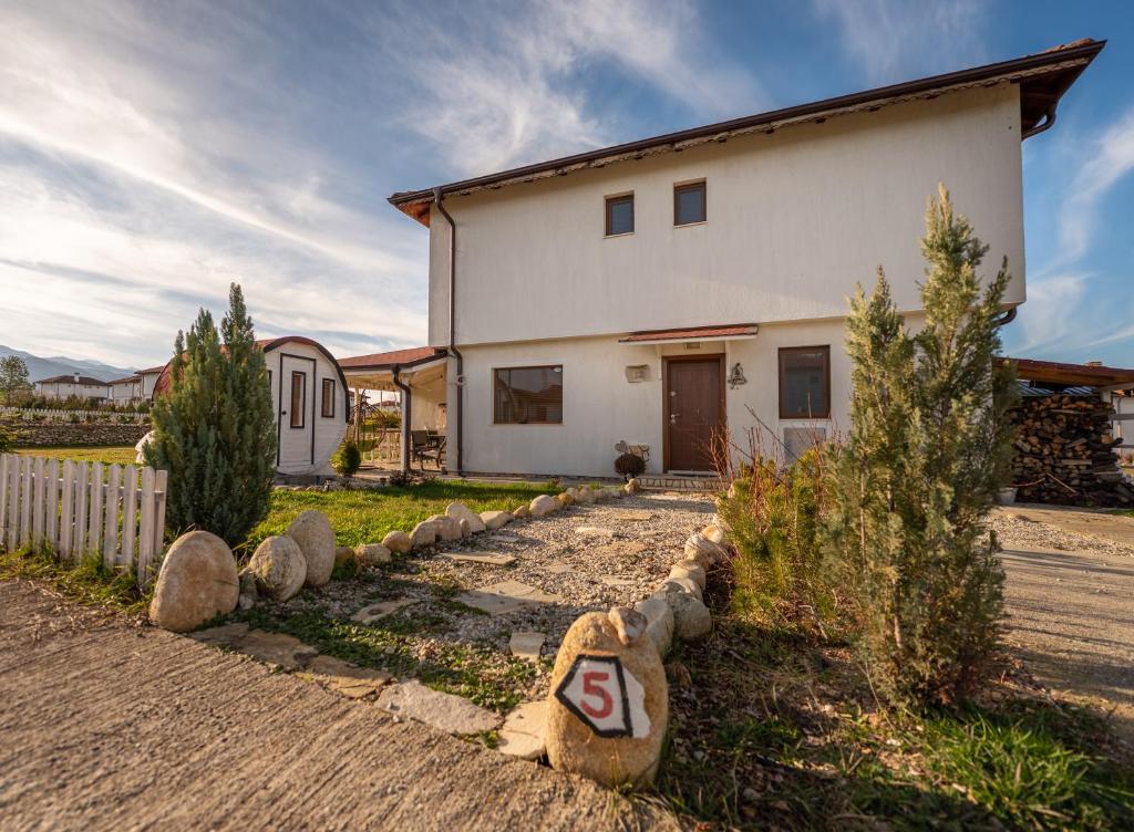 a house with a teddy bear on the side of the road at Къща за гости В 12 и 5 in Dolna Banya