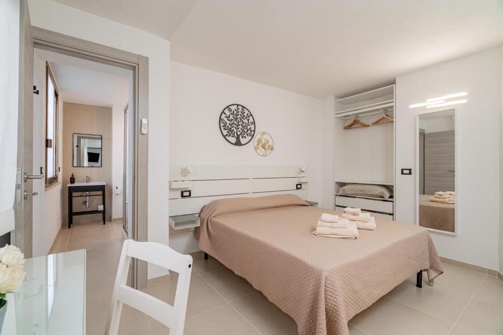 a bedroom with a bed and a table and a chair at Domo Le Mura Puniche, nel cuore di Olbia in Olbia