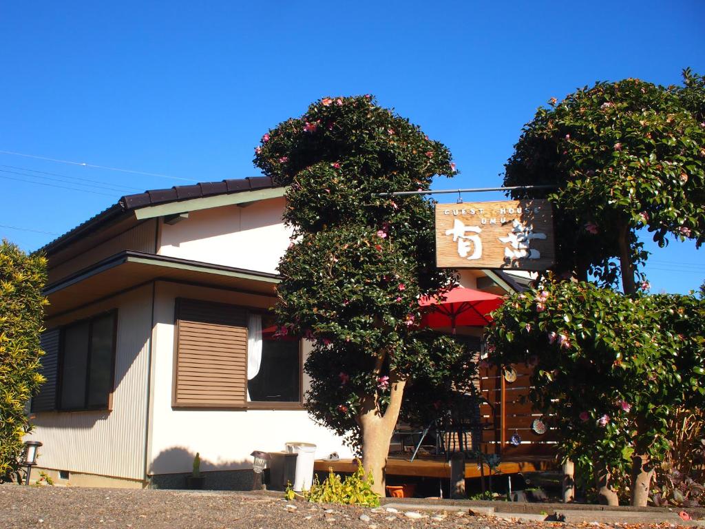 a building with a tree in front of it at ゲストハウス有無 in Mihama