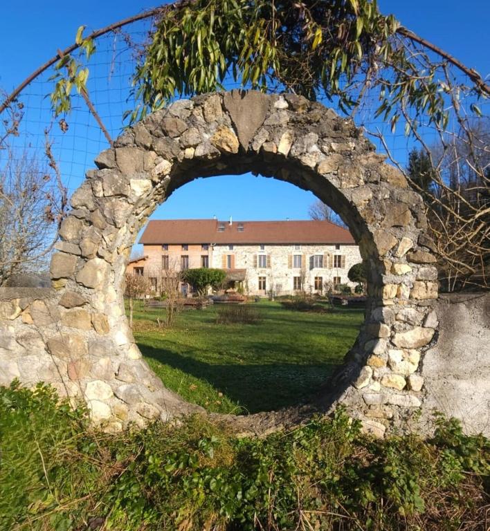 an arch in a stone wall in front of a building at La Ferme Bugiste - Maison de caractère in Belley