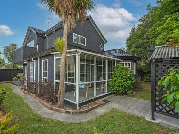 a house with a conservatory with a palm tree at City centred living! in Palmerston North
