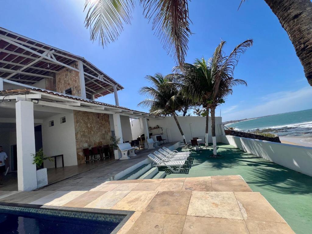 a resort with a pool and palm trees and the ocean at Casa La France in Caucaia