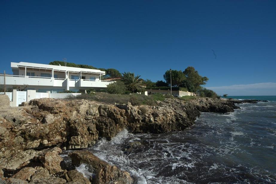 a building on a cliff next to the water at CASA sugli SCOGLI in Fontane Bianche