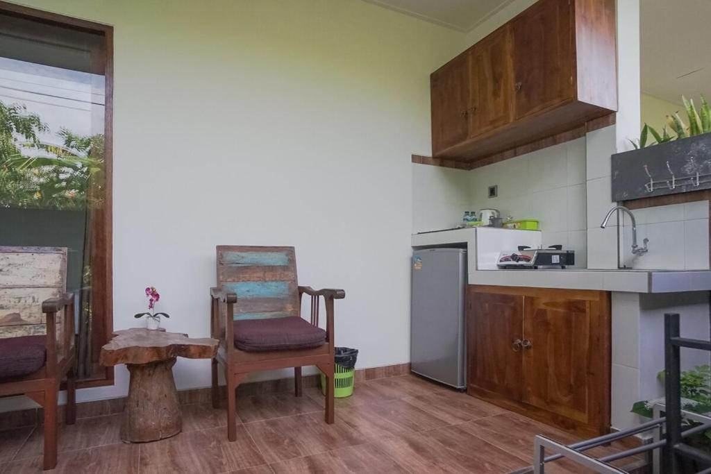a kitchen with a chair and a refrigerator at Rumah Kecil kesari in Denpasar