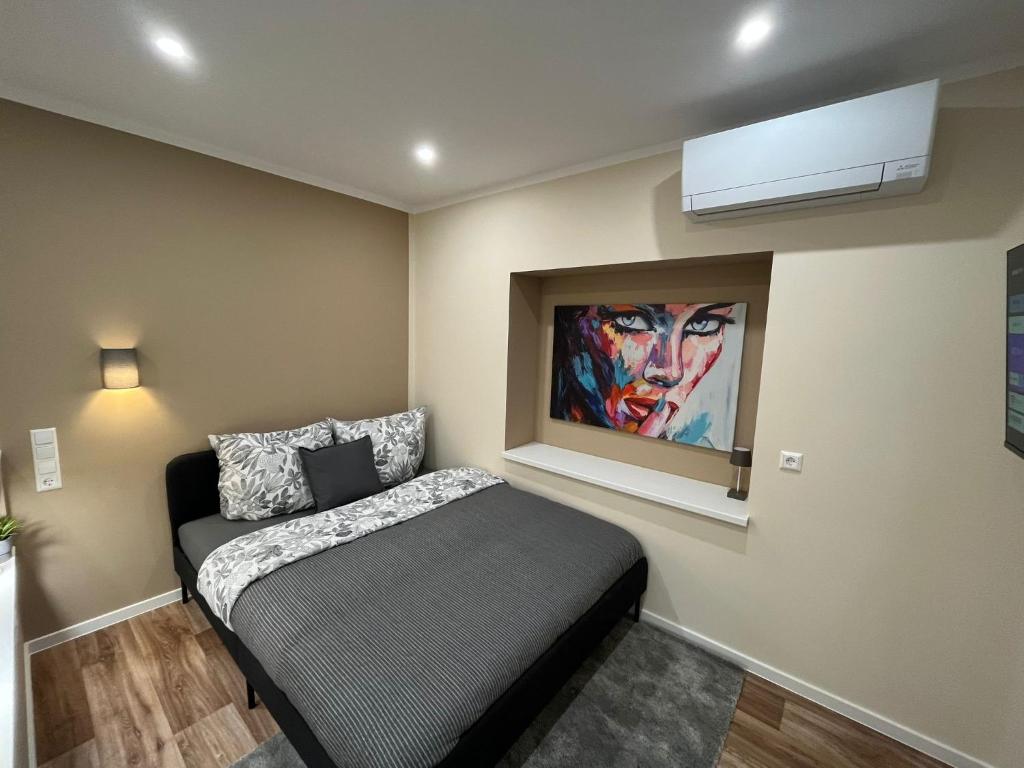 a bedroom with a bed and a painting on the wall at Lumio Apartment 3 - Klimatisiert - Coffee for free - in Karlsruhe
