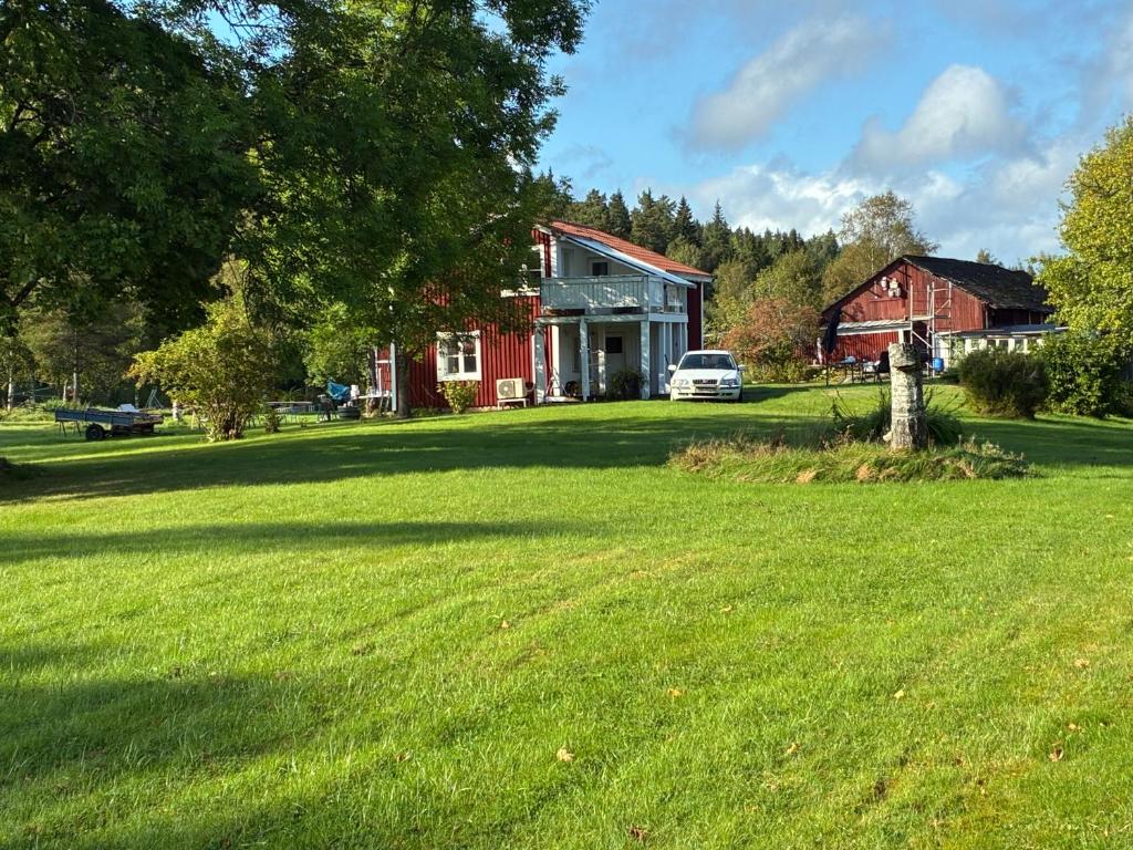 a large yard with a red barn and a house at Lillhuset Gallerud in Årjäng