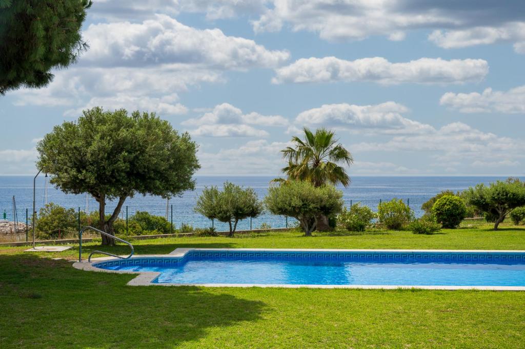 a swimming pool with the ocean in the background at AT084 Piscina compartida con 3 casas y vistas al mar in Torredembarra