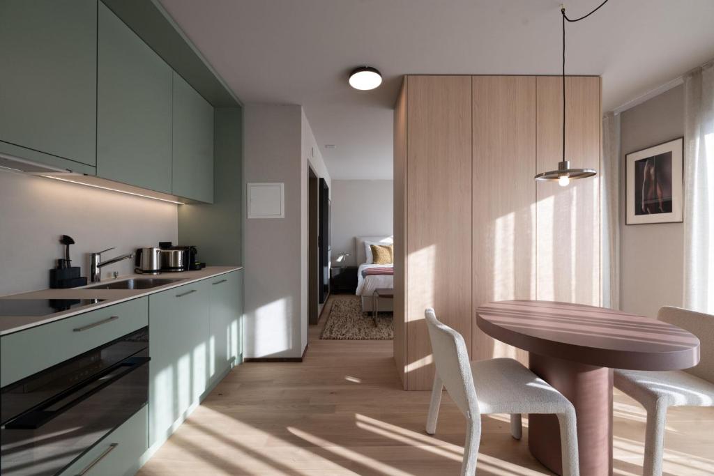 a kitchen with a table and chairs and a room at Stadtloft Suites Cham-Zug in Cham